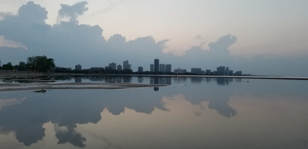 A weather pattern reflected in the still water of Montrose Harbor as seen from Montrose Beach.