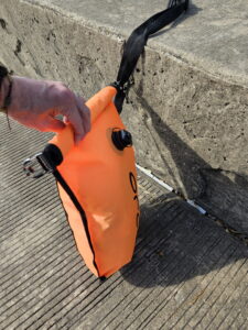 Fourth fold of the open water swim buoy dry bag closure ready to close an open water swim buoy